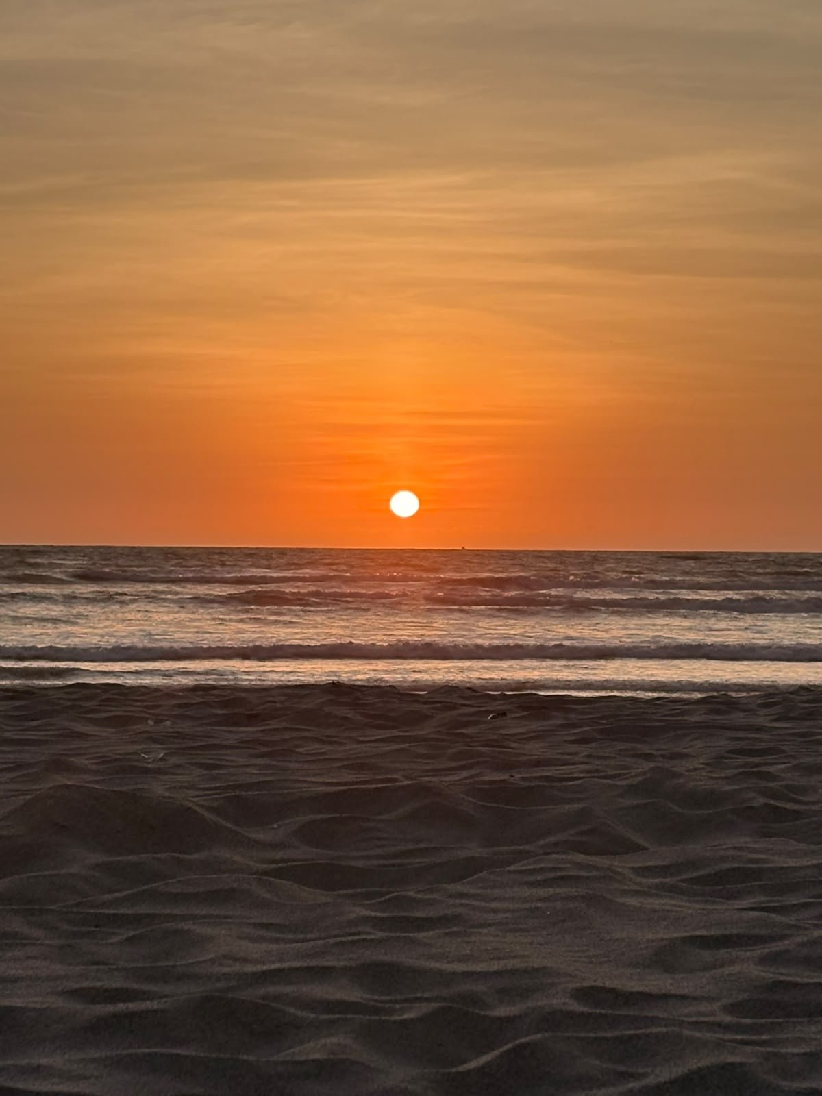 El sol sobre el horizonte del Pacífico visto desde la arena